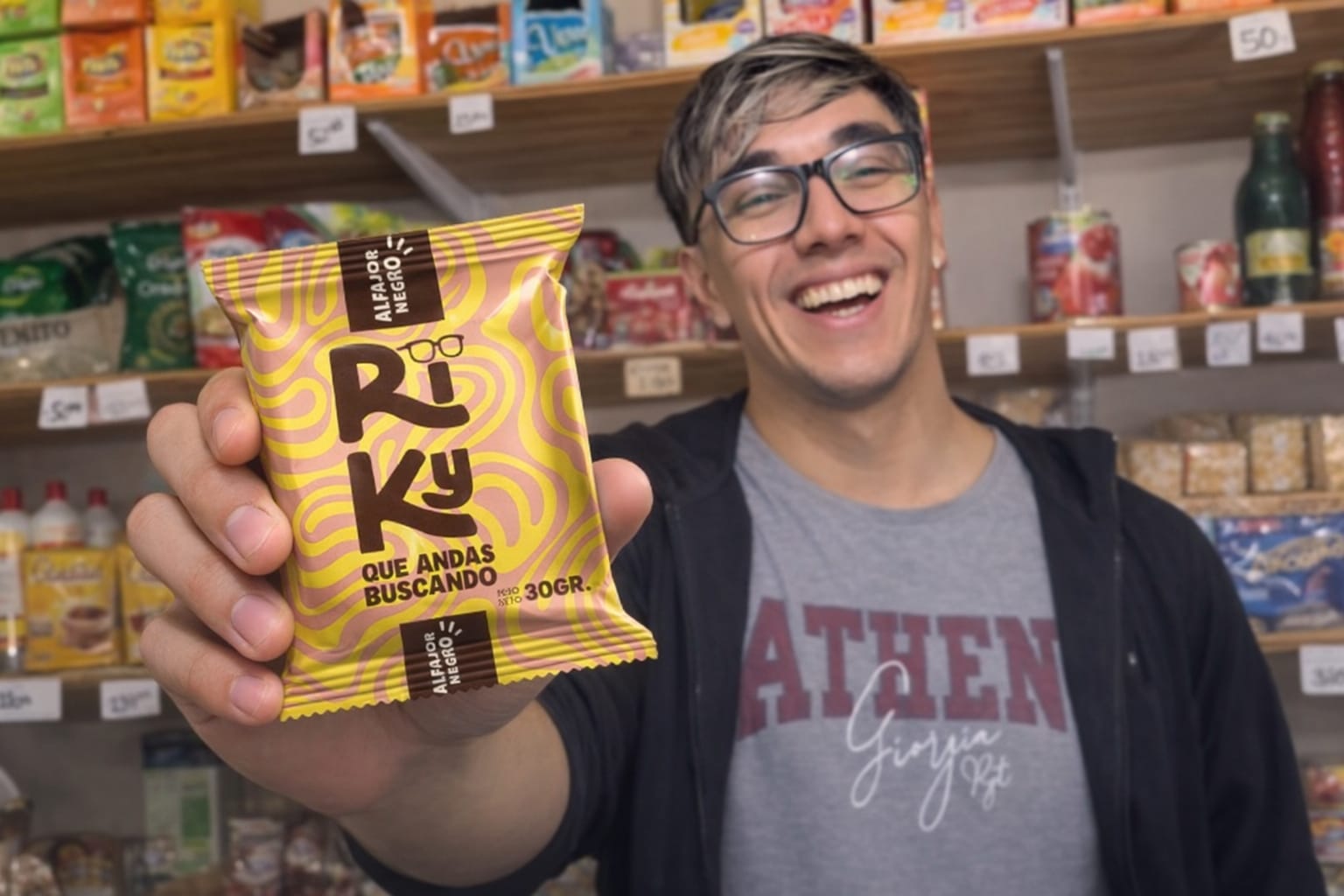 Ricky Salvatierra sosteniendo un alfajor RIKY en un kiosco.